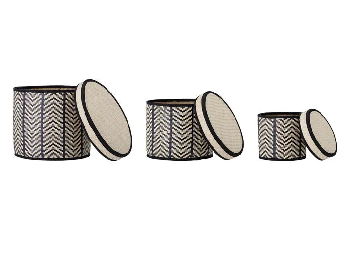 Tre runde, sorte og beige flettede opbevaringskurve med låg, vist i små, mellemstore og store størrelser, med et chevronmønster.