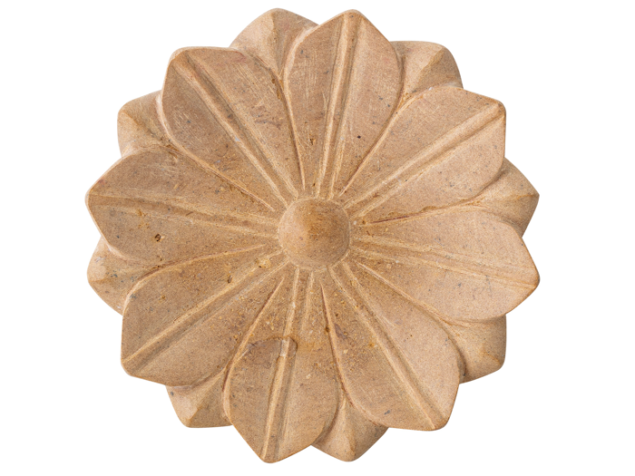 En rund, brunfarvet genstand formet som en blomst med udskårne kronblade og en hævet midte, der ligner en dekorativ sten eller sæbe.