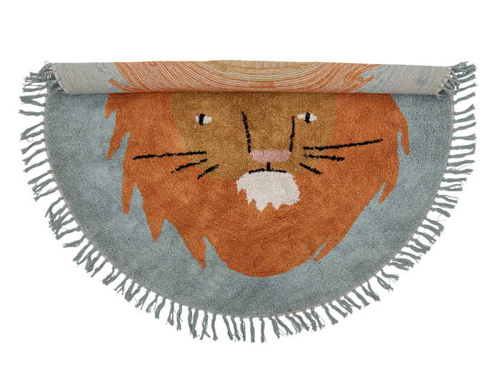 Et halvcirkelformet tæppe med en frynset kant, der viser et tegneserie-løveansigt med brun manke og lyseblå baggrund. Tæppet er delvist rullet sammen i toppen.