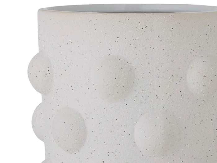 Et nærbillede af en hvid, struktureret keramikvase med hævede, cirkulære buler i rækker på overfladen.