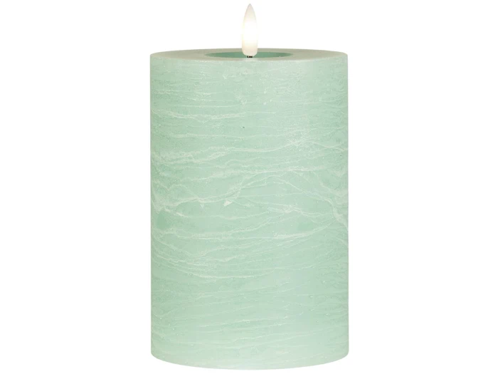 Et tændt, lysegrønt bloklys med en struktureret overflade, vist mod en hvid baggrund.