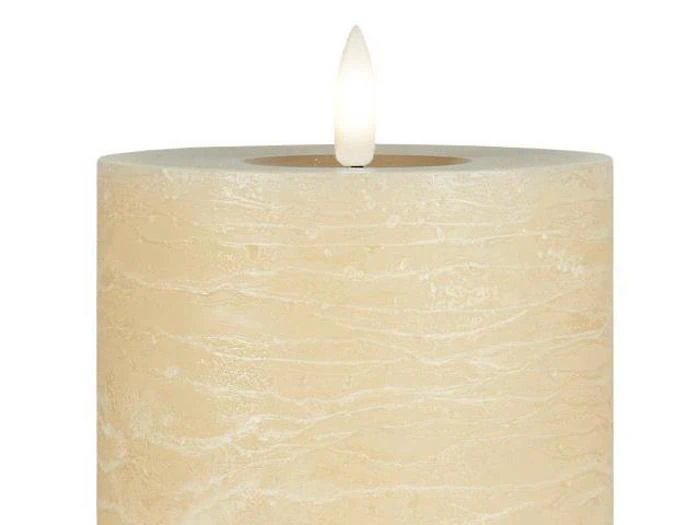 Et beige, struktureret bloklys med en realistisk udseende kunstig flamme i toppen.