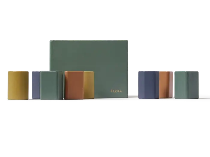 En grøn, rektangulær kasse mærket FLEXA med seks farverige, blokformede genstande i forskellige farver ved siden af.