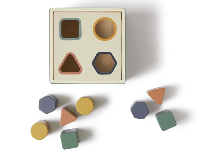 Et formsorteringslegetøj i træ med huller til firkanter, cirkler, trekanter og sekskanter og matchende farvede klodser placeret rundt om det.