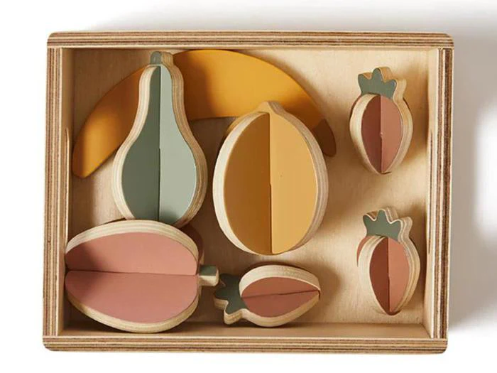 Legetøjsfrugtsæt af træ i en kasse med en banan, pære, appelsin, to jordbær og en blomme, hver frugt opdelt i separate farvede segmenter.