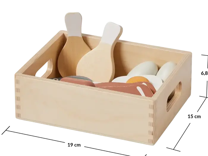 En trækasse med legetøjskøkkenredskaber og madvarer i træ, bl.a. æg og spatler.