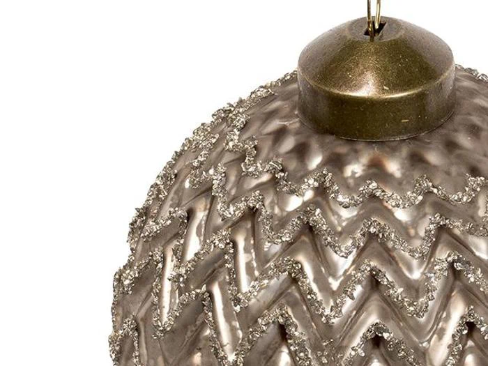 Nærbillede af en metallisk julekugle med et glitrende zigzag-mønster og en guldhætte i toppen.