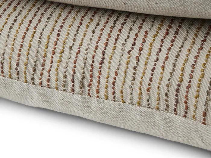 Nærbillede af to puder i beige stof, den ene med et mønster af lodrette røde, gule og brune striber. Teksturen og syningsdetaljerne er synlige.