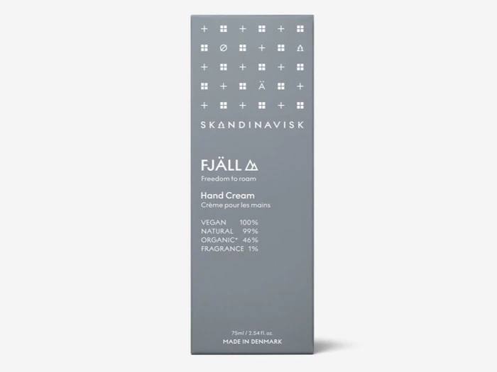 En grå æske med Skandinavisk Fjäll håndcreme, der er mærket som vegansk, 99 % naturlig, 4 % økologisk, 1 % parfume og fremstillet i Danmark.