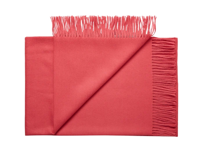 Et pænt foldet rødt tørklæde med frynsede kanter, vist på en hvid baggrund. Det ene hjørne af tørklædet er vendt, så man kan se undersiden og frynserne.