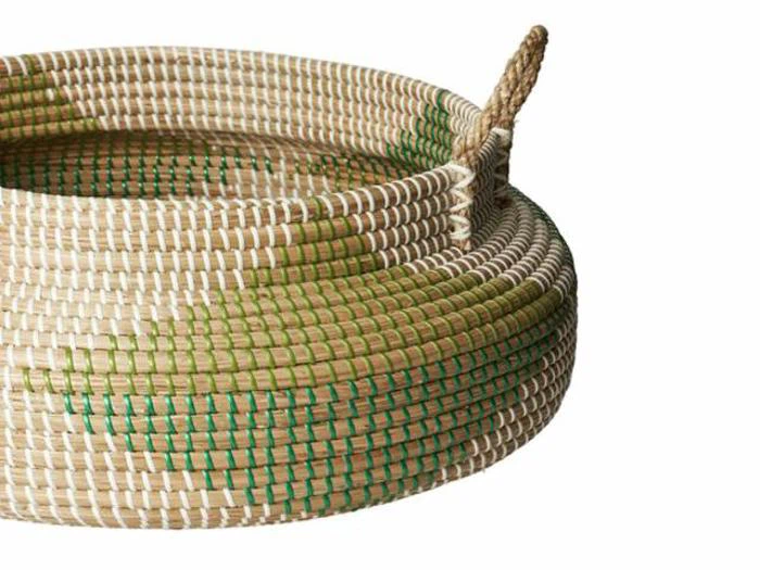 Et oprullet reb med beige, grønne og hvide tråde, der ligger på en hvid baggrund. Den ene ende af rebet stikker ud fra spolen.