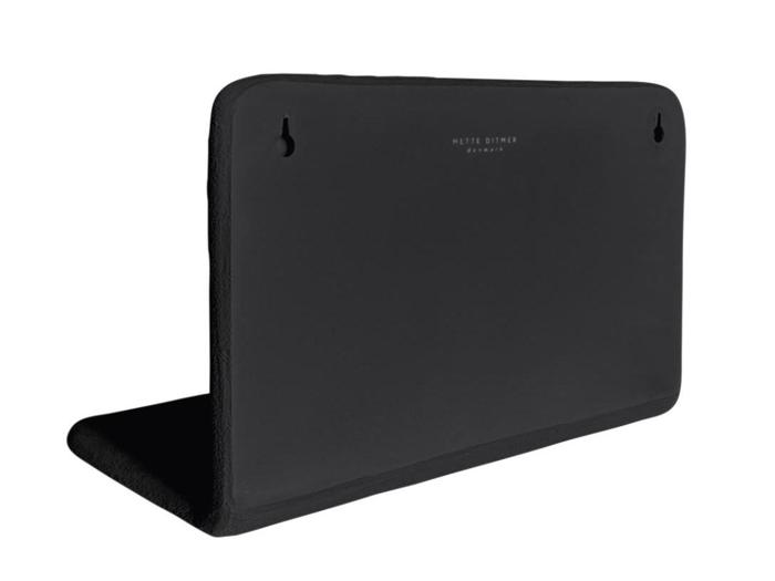 Et sort, L-formet akustikpanel med to monteringshuller og etiketten Mette Ditmer Denmark i øverste højre hjørne.