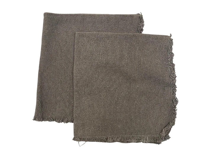To foldede, rektangulære, gråbrune, vævede stofservietter med let flossede kanter, placeret overlappende på en hvid baggrund.