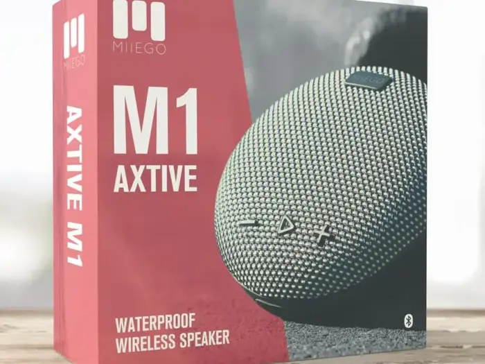 Æske med en MIIEGO M1 Axtive vandtæt trådløs højttaler, der viser et billede af den runde, strukturerede højttaler med kontrolknapper og Bluetooth-symbol.