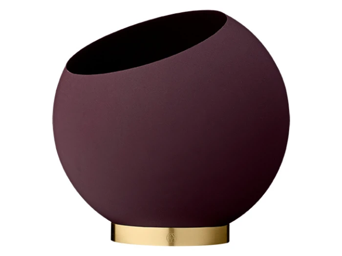 En rund, mørklilla vase med skrå åbning står på en guldmetallic base mod en hvid baggrund.