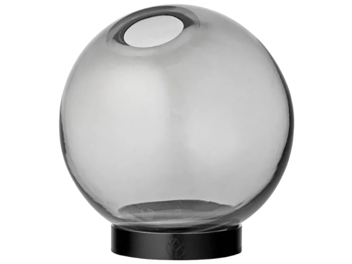 En gennemsigtig, røggrå glaskugle med en rund åbning i toppen, der hviler på en flad, sort, cirkulær base.