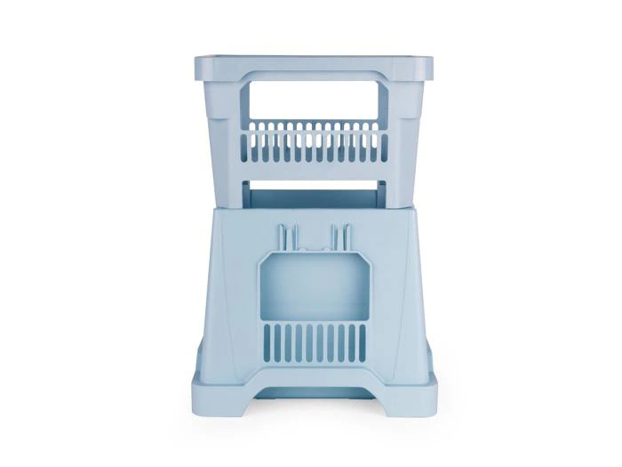 To lyseblå opbevaringskasser i plast er stablet oven på hinanden mod en hvid baggrund. Kasserne har ventilerede sider og håndtag.