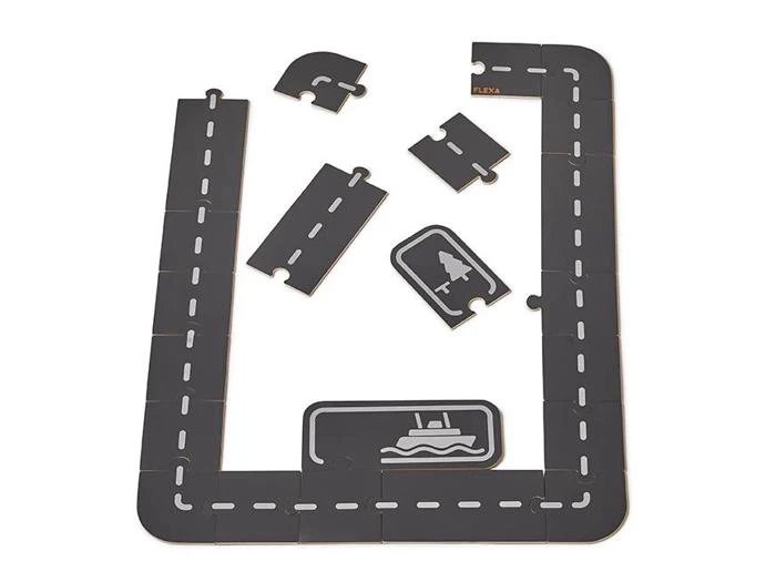 Et sort legetøjsbanesæt med hvide stiplede linjer, arrangeret i et rektangel med flere ekstra buede og lige brikker, plus illustrerede park- og havnefliser.