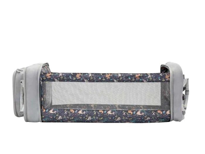 En bærbar sengehest i stof med grå ender, net i midten og et mønster af dyr og træer langs siderne, designet til børns sikkerhed.