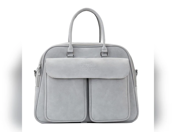 Lysegrå håndtaske med to korte hanke, en stor klaplomme foran og to lodrette lynlåslommer. Enkelt, moderne design med en glat, ruskindslignende tekstur.