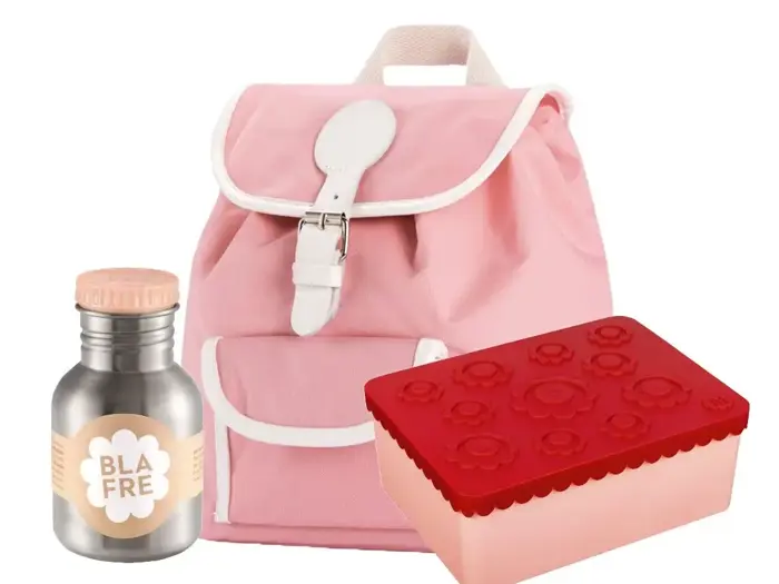 En pink rygsæk, en sølvfarvet vandflaske med beige hætte og en rød madkasse med blomstermønster på låget.