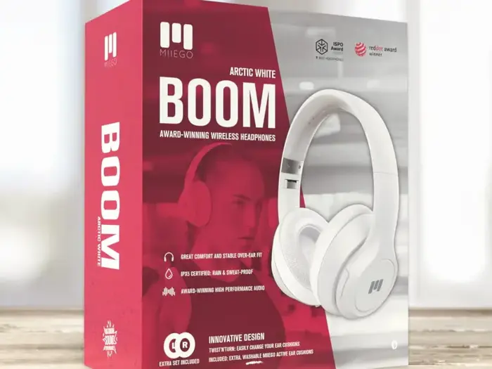 En rød og hvid detailæske viser MIEGO Arctic White BOOM trådløse hovedtelefoner med produktbilleder og nøglefunktioner i hvid tekst på forsiden.