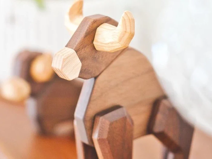 Nærbillede af en legetøjstyr af træ med lyse horn og et geometrisk, minimalistisk design.