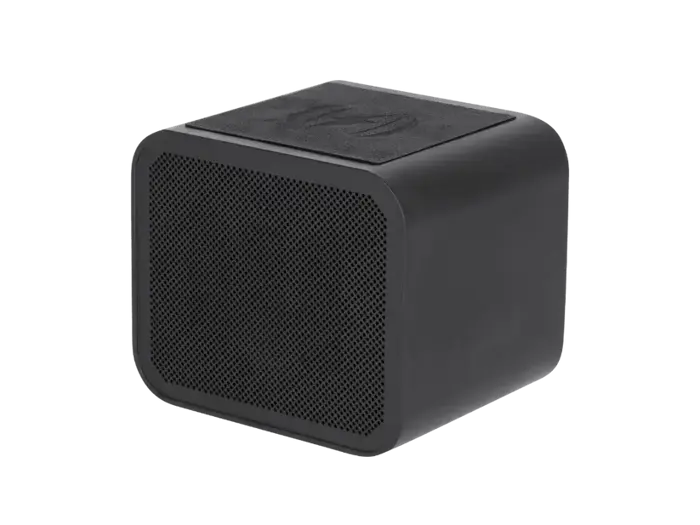 En lille, sort, rektangulær trådløs højttaler med en netfront og en struktureret overside, fotograferet på en almindelig baggrund.