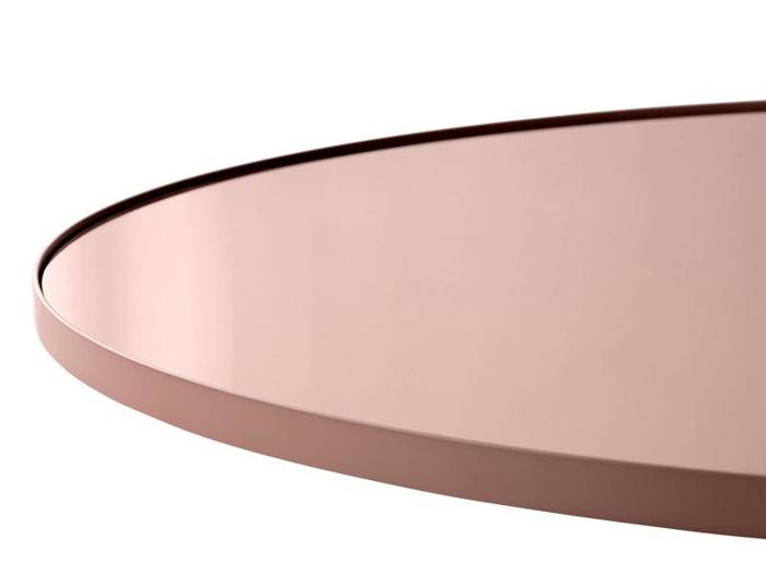 Nærbillede af en rund, rosaguld- eller kobberfarvet metalbakke eller bordplade med en glat, reflekterende overflade mod en hvid baggrund.