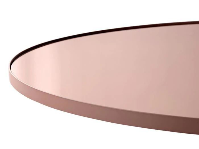 Et nærbillede af en rund, pink metalbakke med hævet kant på en hvid baggrund.