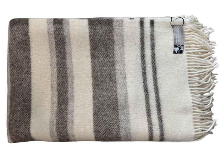 Foldet uldtæppe med grå og hvide striber, frynsede kanter og et lille mærke med metalclips i det ene hjørne.