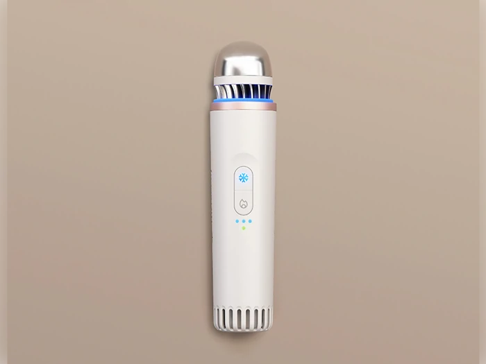 En slank, cylindrisk hvid håndholdt enhed med en metallisk top, blåt lys og kontrolknapper, placeret lodret på en beige baggrund.
