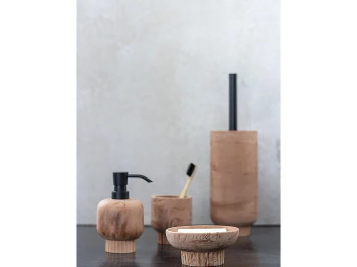 Et sæt badeværelsestilbehør i træ består af en sæbedispenser, en kop med tandbørste, en sæbeskål med sæbe og en toiletbørsteholder, alt sammen på en mørk overflade mod en lys baggrund.