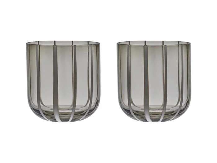 To gennemsigtige, gråtonede glasbægre med lodrette stribemønstre er placeret side om side på en hvid baggrund.