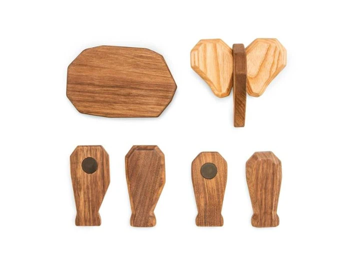 Fem træstykker i forskellige former og nuancer er arrangeret på en hvid baggrund, herunder et, der ligner et elefanthoved, og andre med afrundede kanter.