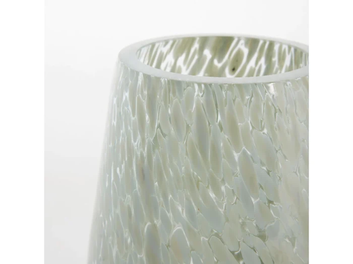 Nærbillede af en gennemskinnelig, struktureret glasvase med et meleret hvidt og gråt mønster mod en almindelig hvid baggrund.
