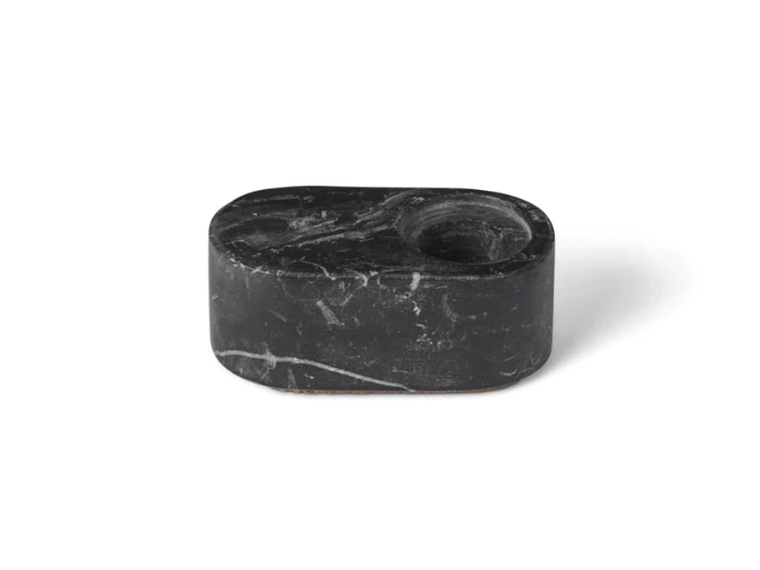 Et lille, ovalt objekt af sort marmor med to runde fordybninger, den ene større end den anden, på oversiden.