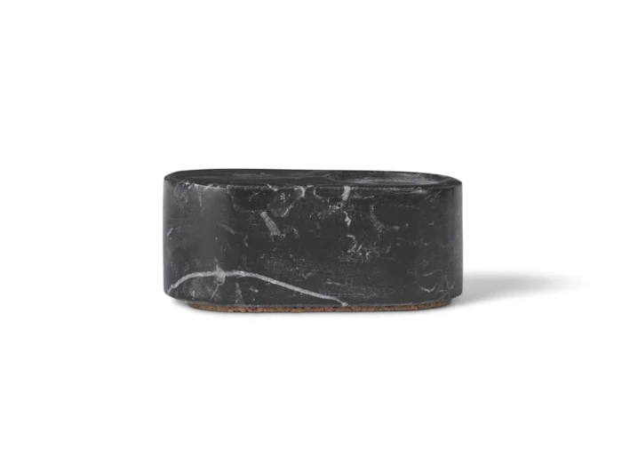 En lille, oval beholder af sort marmor med låg, hvide årer og korkbund på en almindelig hvid baggrund.