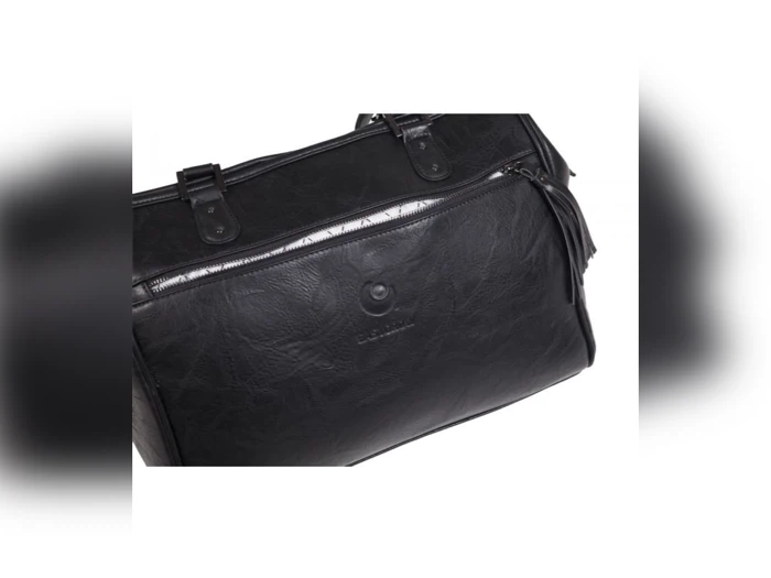 Et nærbillede af en sort læderhåndtaske med synlige syninger, en lynlåslomme og to hanke.