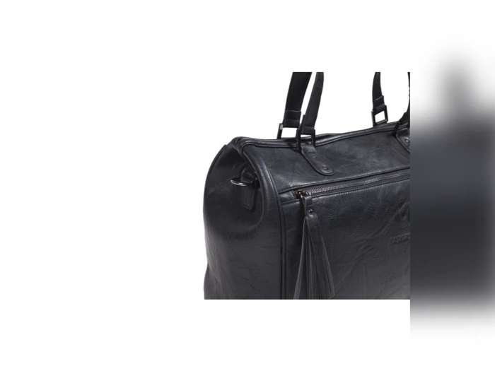 Et nærbillede af en sort læderhåndtaske med to hanke og en lynlåslomme på siden, vist mod en hvid baggrund.