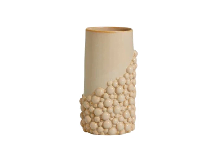 En beige keramikvase med en glat overflade på toppen og en klynge ophøjede runde perler, der dækker den nederste halvdel, på en hvid baggrund.