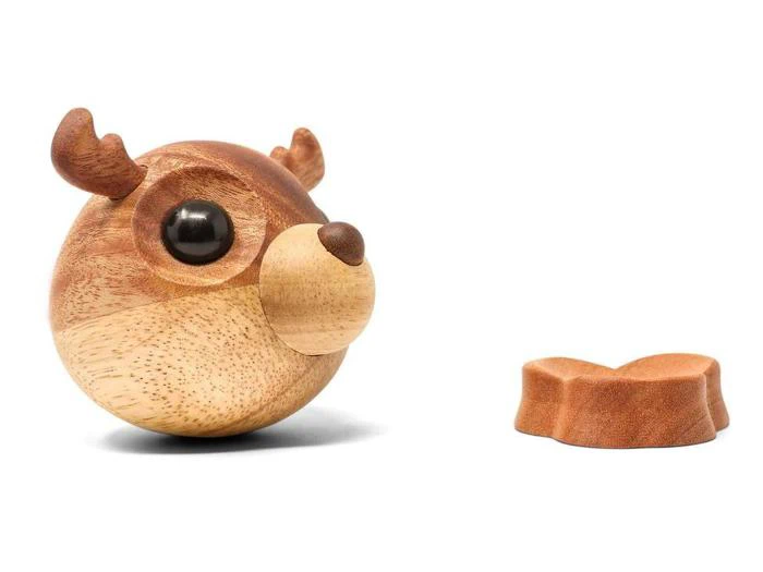 En rund rensdyrfigur af træ med gevir og et separat gevirformet stykke af træ placeret ved siden af på en hvid baggrund.