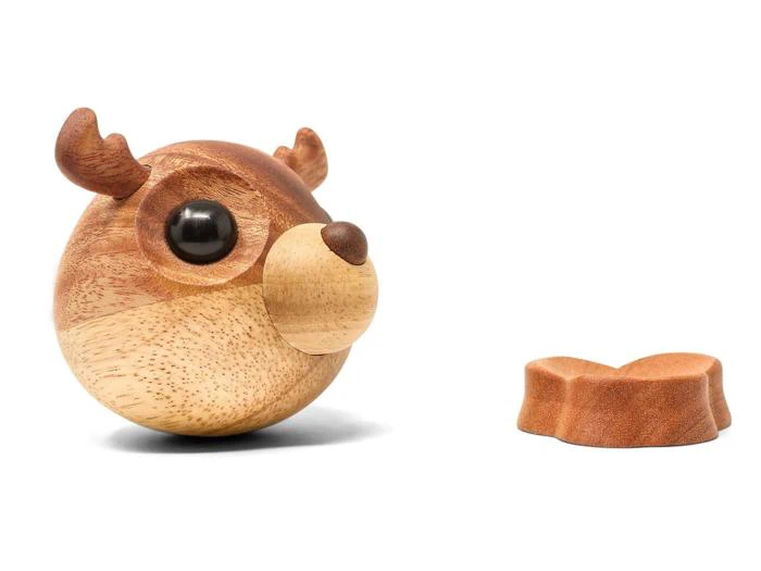 En rund træfigur af et rensdyr med sorte øjne og gevir ved siden af en separat træfigur i samme farve på en hvid baggrund.