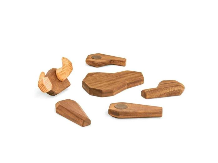 Seks stykker trælegetøj, herunder et formet som et dyrehoved med horn og fem geometriske figurer, er arrangeret på en hvid baggrund.