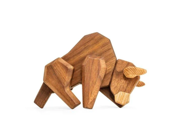 En træskulptur af en bøffel, udformet med enkle geometriske former og glat finish, der står på en hvid baggrund.