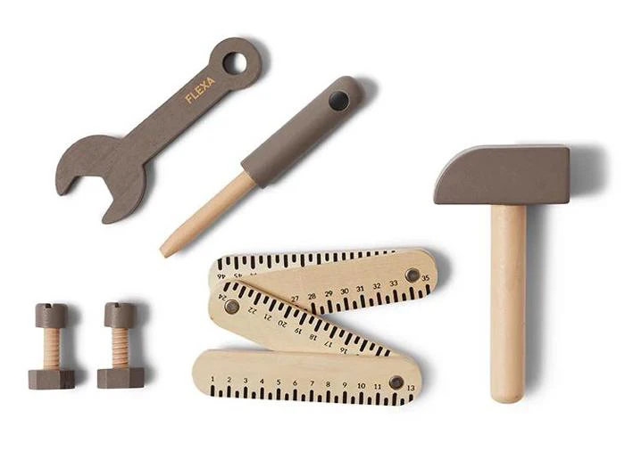 Legetøjsværktøj af træ, bl.a. en skruenøgle, skruetrækker, hammer, tommestok og to bolte med møtrikker, arrangeret på en hvid baggrund.