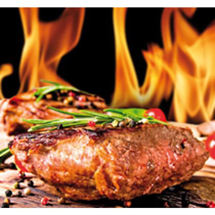 Grillet bøf garneret med krydderurter og peberkorn, mens flammerne stiger i baggrunden.