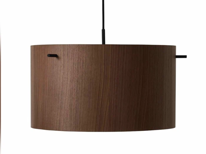 En moderne cylindrisk pendel med en mørk træfinish, ophængt i en sort ledning mod en hvid baggrund.