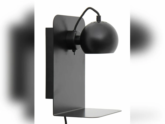 En moderne sort væghængt lampe med en afrundet, justerbar skærm og en flad, nedre hylde på en hvid baggrund.