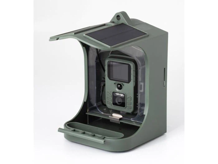 Et grønt, kasseformet udendørs kameraskab med en åben front, der rummer et trail-kamera indeni. Kabinettet har et solpanel på toppen.
